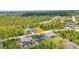 Aerial view of a home with lush greenery, neighboring houses, and a blue sky overhead at 8489 Topeka Cir, Port Charlotte, FL 33981