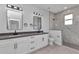 Bright bathroom featuring double sinks, square mirrors, and a large walk-in shower with modern gray and white tiling at 8489 Topeka Cir, Port Charlotte, FL 33981