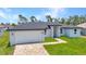 Charming single-story home with a brick driveway and lush green lawn at 8489 Topeka Cir, Port Charlotte, FL 33981