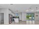 Spacious kitchen features white cabinetry, stainless steel appliances, an island, and a large window overlooking the backyard at 8489 Topeka Cir, Port Charlotte, FL 33981