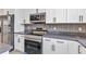 Modern kitchen featuring white cabinets, stainless steel appliances, and gray countertops at 8489 Topeka Cir, Port Charlotte, FL 33981