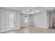 Bright living room featuring a tile floor, modern light fixture, recessed ceiling, and a glass panel door at 8489 Topeka Cir, Port Charlotte, FL 33981