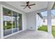 Covered patio with tile flooring, ceiling fan, and a sliding glass door to the home's interior at 8489 Topeka Cir, Port Charlotte, FL 33981