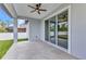 The covered patio features gray tile flooring, a ceiling fan, and sliding glass doors at 8489 Topeka Cir, Port Charlotte, FL 33981