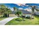 House with circular driveway and tropical landscaping at 39 Tee View Pl, Rotonda West, FL 33947