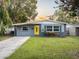 Charming ranch home with a yellow door and well-maintained lawn at 304 W Fern St, Tampa, FL 33604