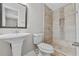 Updated bathroom with pedestal sink, shower, and tile flooring at 304 W Fern St, Tampa, FL 33604