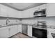 Modern kitchen with white cabinets, stainless steel appliances, and granite countertops at 304 W Fern St, Tampa, FL 33604