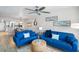 Bright living room with two blue couches, coffee table, and view into dining area at 20000 Gulf Blvd # 707, Indian Shores, FL 33785