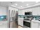 Stainless steel appliances and teal backsplash in updated kitchen at 20000 Gulf Blvd # 707, Indian Shores, FL 33785