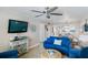 Living room featuring blue couches, a TV, and a view into the dining area at 20000 Gulf Blvd # 707, Indian Shores, FL 33785