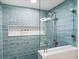 Walk-in shower with blue tile and built-in shelf at 20000 Gulf Blvd # 707, Indian Shores, FL 33785