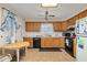 Cozy kitchen features wood cabinets, black appliances, and a small dining area at 5846 Greenbriar Ct, Zephyrhills, FL 33542