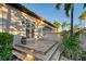 Side exterior elevation of the home with double doors, tile steps, and tropical plants at 6918 Belmont Ct, Lakewood Ranch, FL 34202