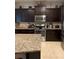 Kitchen with dark wood cabinets, granite countertops, and stainless steel appliances at 6327 Yellow Buckeye Dr # 6327, Riverview, FL 33578