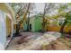 Unique green home design with a sandy lot and fenced perimeter, surrounded by mature trees offering ample shade at 10020 Jungle St, New Port Richey, FL 34654
