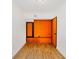 A vibrant room featuring hardwood flooring, orange accent wall and white walls at 10020 Jungle St, New Port Richey, FL 34654