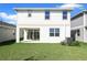 The two story home has a backyard with green lawn and a covered patio at 5936 Jensen View Ave, Apollo Beach, FL 33572