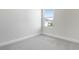 Clean bedroom with neutral carpet, white baseboards, and a window for ample light at 5936 Jensen View Ave, Apollo Beach, FL 33572