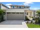 Inviting two-story home with stone accents, manicured lawn, and an attached two-car garage at 5936 Jensen View Ave, Apollo Beach, FL 33572
