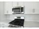 Modern stainless steel microwave and gas range, complemented by white cabinets and countertops at 5936 Jensen View Ave, Apollo Beach, FL 33572
