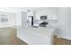Well-lit kitchen with stainless steel appliances, white cabinets, and spacious quartz countertop island at 5936 Jensen View Ave, Apollo Beach, FL 33572