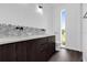 Modern bathroom featuring dark wood cabinets, a unique scalloped tile backsplash, and a window view at 501 Chastain Rd, Seffner, FL 33584
