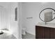 Modern bathroom with a dark wood vanity, round mirror, and tiled shower at 501 Chastain Rd, Seffner, FL 33584