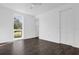 Bright bedroom with dark wood-style floors, large window, and white walls at 501 Chastain Rd, Seffner, FL 33584