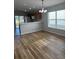 Dining area with wood-look flooring, chandelier, and adjacent kitchen at 7920 Carriage Pointe Dr, Gibsonton, FL 33534