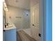 Modern bathroom with double vanity, walk-in shower, and gray tile at 5161 Churchill Rd, Port Charlotte, FL 33981