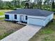 A newly constructed single-story home with a gray roof and a paved driveway at 22112 Mamaroneck Ave, Port Charlotte, FL 33952