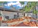 Backyard view features a brick pathway, air conditioning units, and mulched landscaping at 407 Belvedere Oval, Temple Terrace, FL 33617
