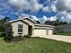 Single-story home with a three-car garage, manicured lawn, and tasteful landscaping, offering great curb appeal at 9049 Players Dr, Weeki Wachee, FL 34613