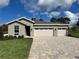 Charming single-story home featuring a three-car garage, a beautiful stone driveway, and lush landscaping at 9049 Players Dr, Weeki Wachee, FL 34613
