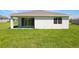 Backyard with green grass, patio with sliding glass doors, and a glimpse of the home's exterior at 9071 Players Dr, Weeki Wachee, FL 34613