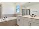 Modern bathroom featuring double vanity, soaking tub, and sleek black fixtures at 9071 Players Dr, Weeki Wachee, FL 34613