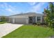Well maintained lawn and landscaping highlight this single-story home with a two car garage and brick paver driveway at 9071 Players Dr, Weeki Wachee, FL 34613