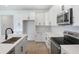 New kitchen featuring white cabinets, quartz countertops, black hardware and stainless steel appliances at 9071 Players Dr, Weeki Wachee, FL 34613