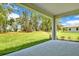 Expansive backyard view from the covered lanai featuring mature trees and green grass at 9093 Players Dr, Weeki Wachee, FL 34613