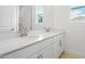 Bright bathroom with double sinks, a large mirror, and white cabinetry at 9093 Players Dr, Weeki Wachee, FL 34613