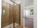 Modern bathroom with glass shower, tan tile, and white cabinets at 9093 Players Dr, Weeki Wachee, FL 34613