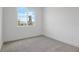 This bedroom features neutral carpeting, white walls, and a bright window overlooking the outdoors at 9093 Players Dr, Weeki Wachee, FL 34613