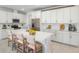 Modern kitchen features white cabinets, stainless steel appliances, and a large island with bar stool seating at 9093 Players Dr, Weeki Wachee, FL 34613