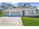 Charming single-Gathering home features a three-car garage, stone accents, and well-manicured lawn at 9109 Players Dr, Weeki Wachee, FL 34613