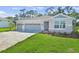 Charming single-Gathering home features a three-car garage, stone accents, and well-manicured lawn at 9109 Players Dr, Weeki Wachee, FL 34613