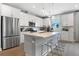 Modern kitchen featuring white cabinets, stainless steel appliances, and a spacious center island at 9109 Players Dr, Weeki Wachee, FL 34613