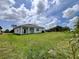 Grassy backyard with ample room for outdoor activities, and features a covered patio at 183 Wright Drive, Rotonda West, FL 33947