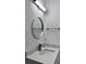Close up on modern bathroom vanity with quartz countertop and round mirror at 183 Wright Drive, Rotonda West, FL 33947