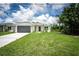 Charming single-story home with a well-manicured lawn, stone accents, and a gray garage door at 183 Wright Drive, Rotonda West, FL 33947